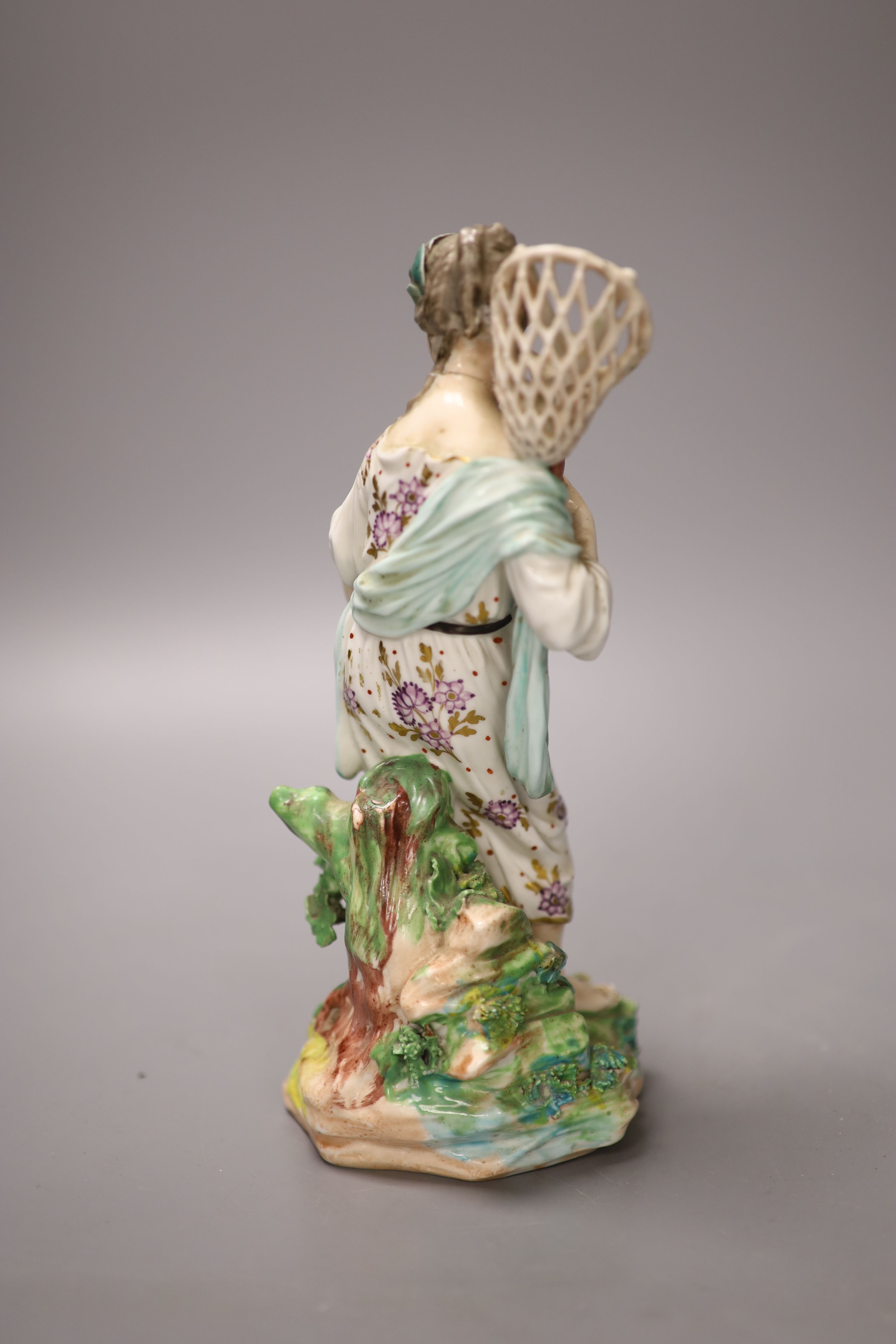 A Derby figure of Water, modelled as a girl holding a fish net her apron holding three fish, stand on a naturalistic beside a black lob